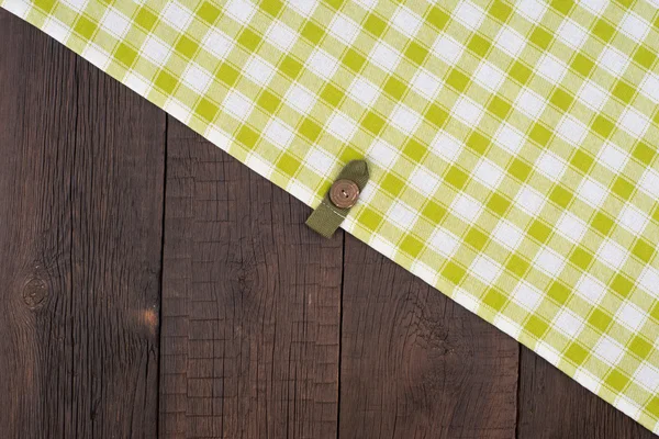 Grün karierte Tischdecke auf Holztisch. — Stockfoto