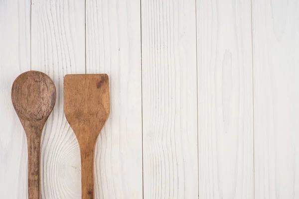 Cucchiaio e spatola in legno su vecchio tavolo bianco . — Foto Stock