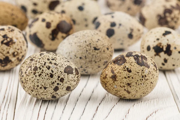 Quail eggs on old white wooden table. — Stock Photo, Image