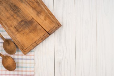 Kesme tahtası ve bir kaşık mutfak peçete üzerinde eski ahşap tabl