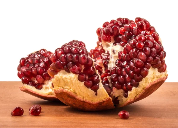 Juicy pomegranates on a wooden table — Stock Photo, Image