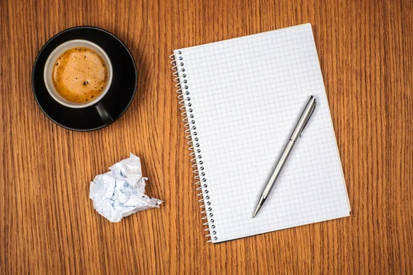Blank notepad and coffee cup on office wooden table — Stock Photo, Image
