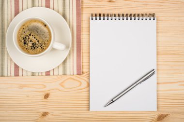 kahve fincanı, spiral defter ve kalem ahşap tablo