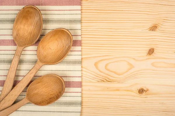 Cucchiaio di legno e strofinaccio su tavola di legno — Foto Stock