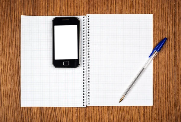 akıllı telefon, kalem ve not etmek üstünde ahşap arka plan yakın çekim