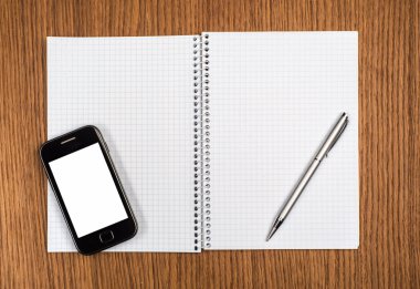 akıllı telefon, kalem ve not etmek üstünde ahşap arka plan yakın çekim
