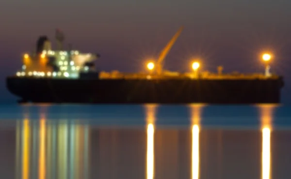 Bokeh van vrachtschip en kraan op poort nadenken over rivier, twilight — Stockfoto