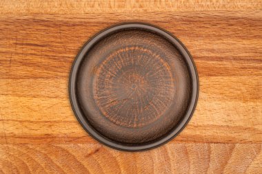 rustik ahşap zemin üzerinde boş kahverengi seramik tabak