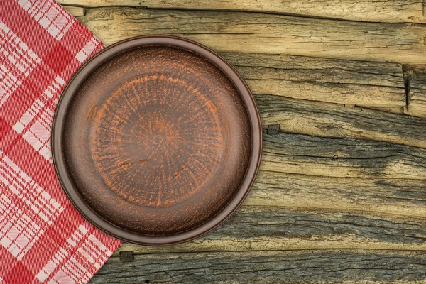 Бурая глиняная тарелка на столе — стоковое фото