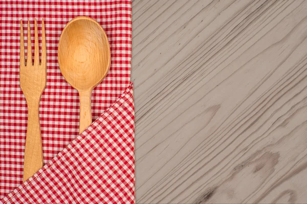 Kitchen tablecloth, fork, spoon on wooden table background — Stock Photo, Image