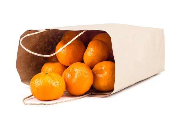 Bolsa de papel con mandarinas maduras. Aislado sobre fondo blanco — Foto de Stock