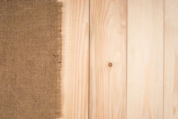 木製のテーブルの背景に黄麻布のテクスチャ — ストック写真