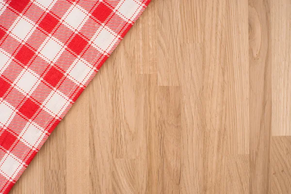 A toalha de mesa quadriculada na mesa de madeira — Fotografia de Stock