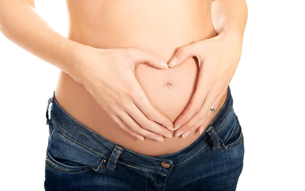 Pregnant woman making heart shape on belly — Stock Photo, Image