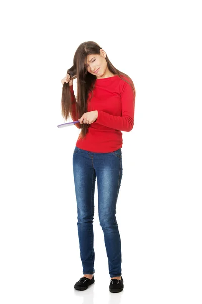 Mujer peinando su cabello enredado . —  Fotos de Stock