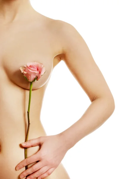 Woman covers breast with flower. — Stock Photo, Image