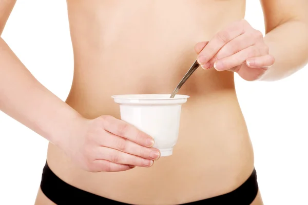 Vrouw in ondergoed eten yoghurt. — Stockfoto