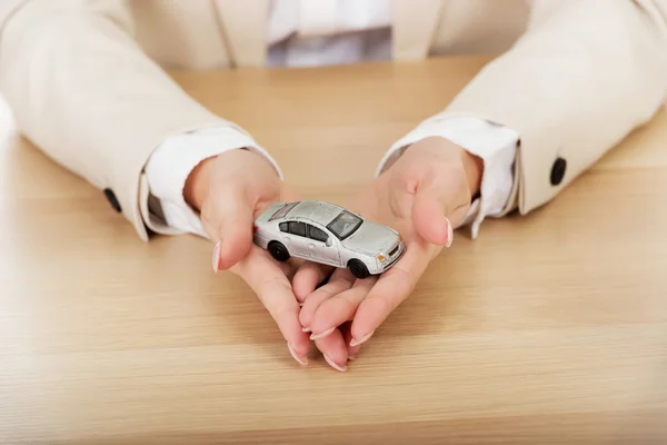 Business woman holding a toy car. — Stock Photo, Image