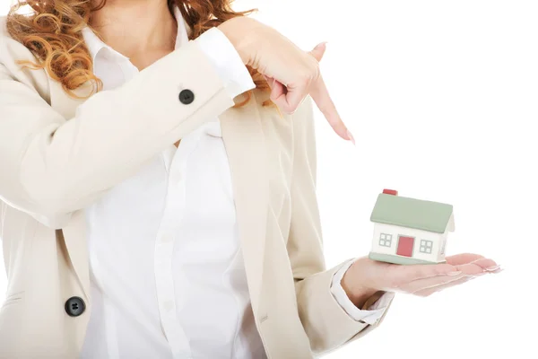 Businesswoman pointing on a model house. — Stock Photo, Image
