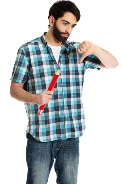 Молодой человек держит большой красный карандаш . — стоковое фото