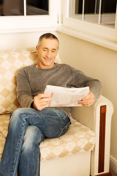 Hombre de mediana edad leyendo el periódico en casa — Foto de Stock