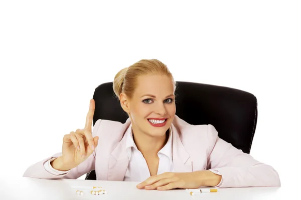 Sourire femme animée avec plusieurs cigarettes sur le bureau — Photo