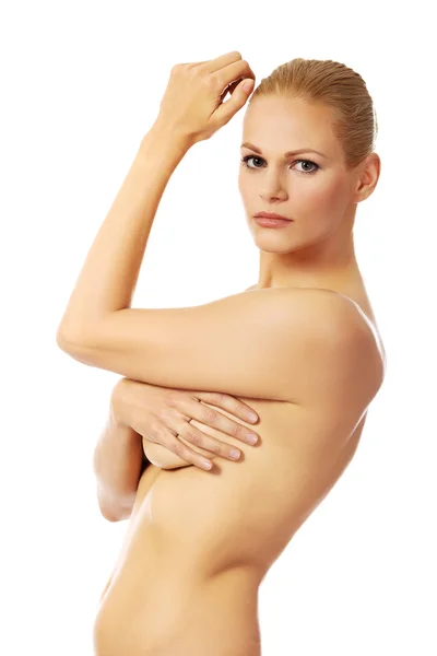 Боковой вид топлесс женщины, покрывающей грудь — стоковое фото