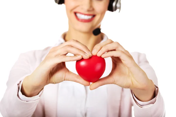 Feliz call center mulher segurando coração brinquedo — Fotografia de Stock