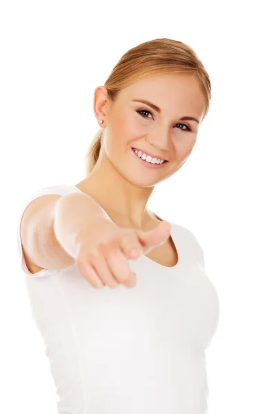 Smiling young woman pointing at camera — Stock Photo, Image