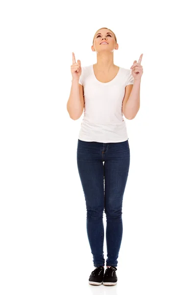 Glad ung kvinna pekar uppåt med båda händerna — Stockfoto