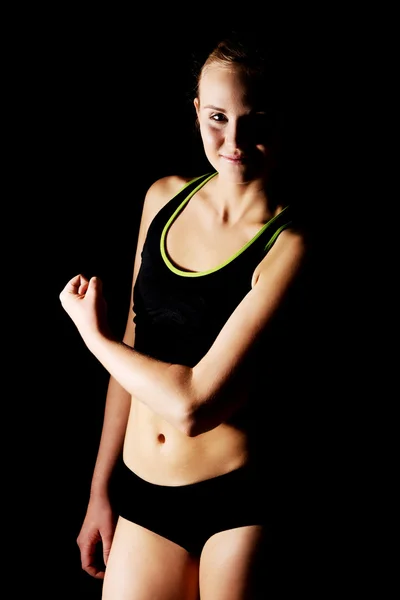 Молодая спортсменка демонстрирует свои мускулы — стоковое фото