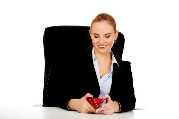 Biznes kobieta siedzi za biurkiem z portfela uśmiech — Zdjęcie stockowe