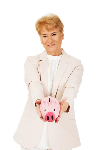 Smile elderly woman holding piggy bank — Stock Photo, Image