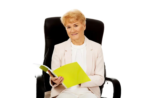 Gülümseme yaşlı iş kadını bir notlar okuma — Stok fotoğraf