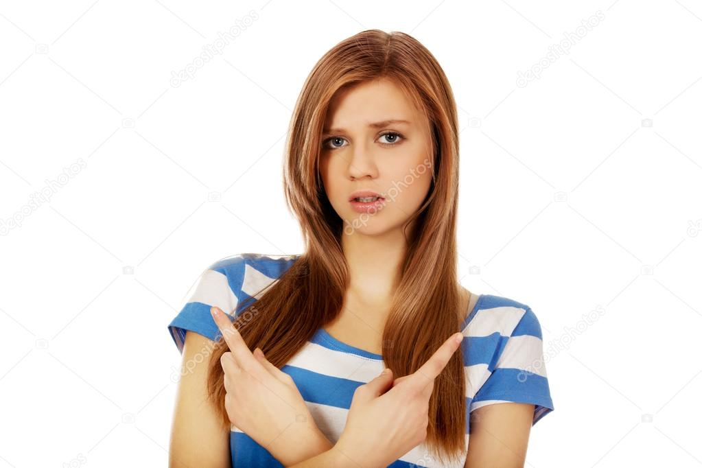 Confused teenage woman pointing in two different directions