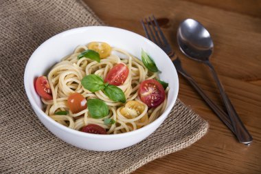 Lezzetli makarna kase ve çatal bıçak takımı ahşap üzerinde ve çuval çuval bezi arka plan