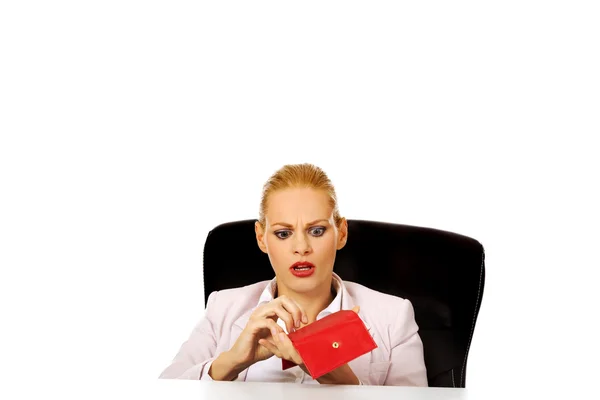 Endişeli iş kadını boş cüzdanla masanın arkasında oturuyor. — Stok fotoğraf