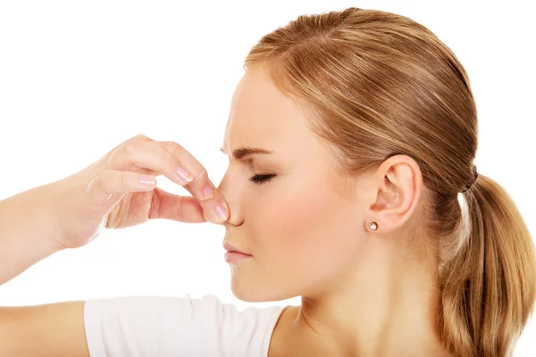 Young woman holding her nose because of a bad smell — Stock Photo, Image