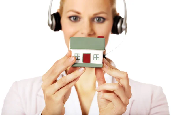 Junge Geschäftsfrau im Headset mit Hausmodell — Stockfoto