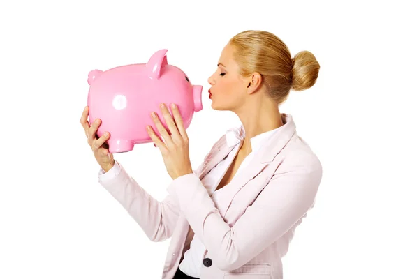 Young business woman kissing a piggybank — Stock Photo, Image