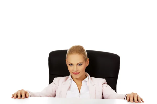 Szczęśliwa kobieta biznesu siedzi za biurkiem — Zdjęcie stockowe