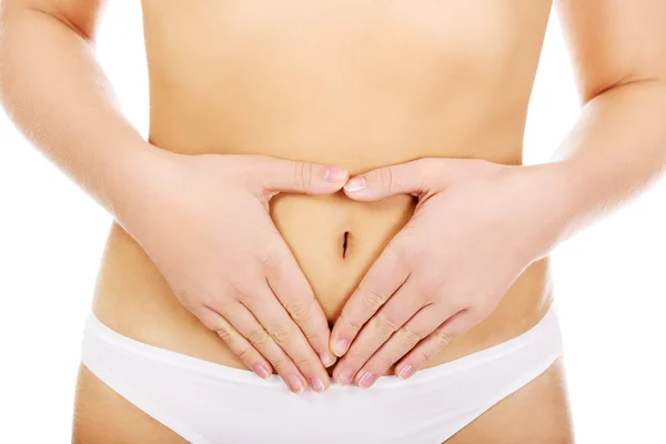 Young woman in white panties making heart shape on her belly — Stock Photo, Image