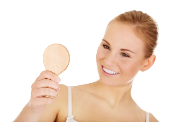 Joven hermosa mujer mirando en un espejo — Foto de Stock