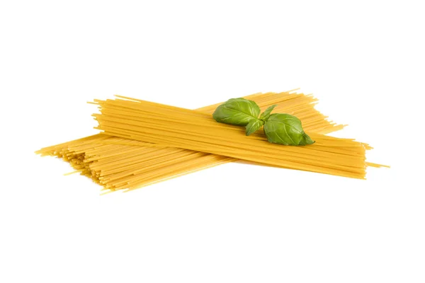 Uncooked dry fettuccine pasta  with green basil — Stock Photo, Image