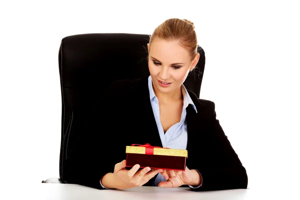 Sorridi donna d'affari con scatola regalo seduta dietro la scrivania — Foto Stock