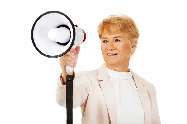 Senior lächelnde Frau schreit durch ein Megafon — Stockfoto