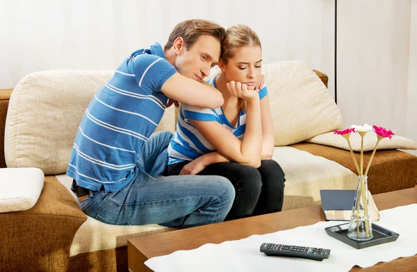 Man troostend zijn boos partner in woonkamer — Stockfoto