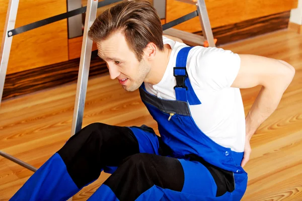 Handyman cayó de una escalera y se sentó en el suelo con dolor de espalda — Foto de Stock