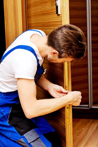 Unge man laga dörren med skruvmejsel — Stockfoto