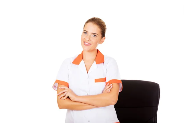 Sonrisa joven doctora o enfermera de pie detrás del escritorio —  Fotos de Stock